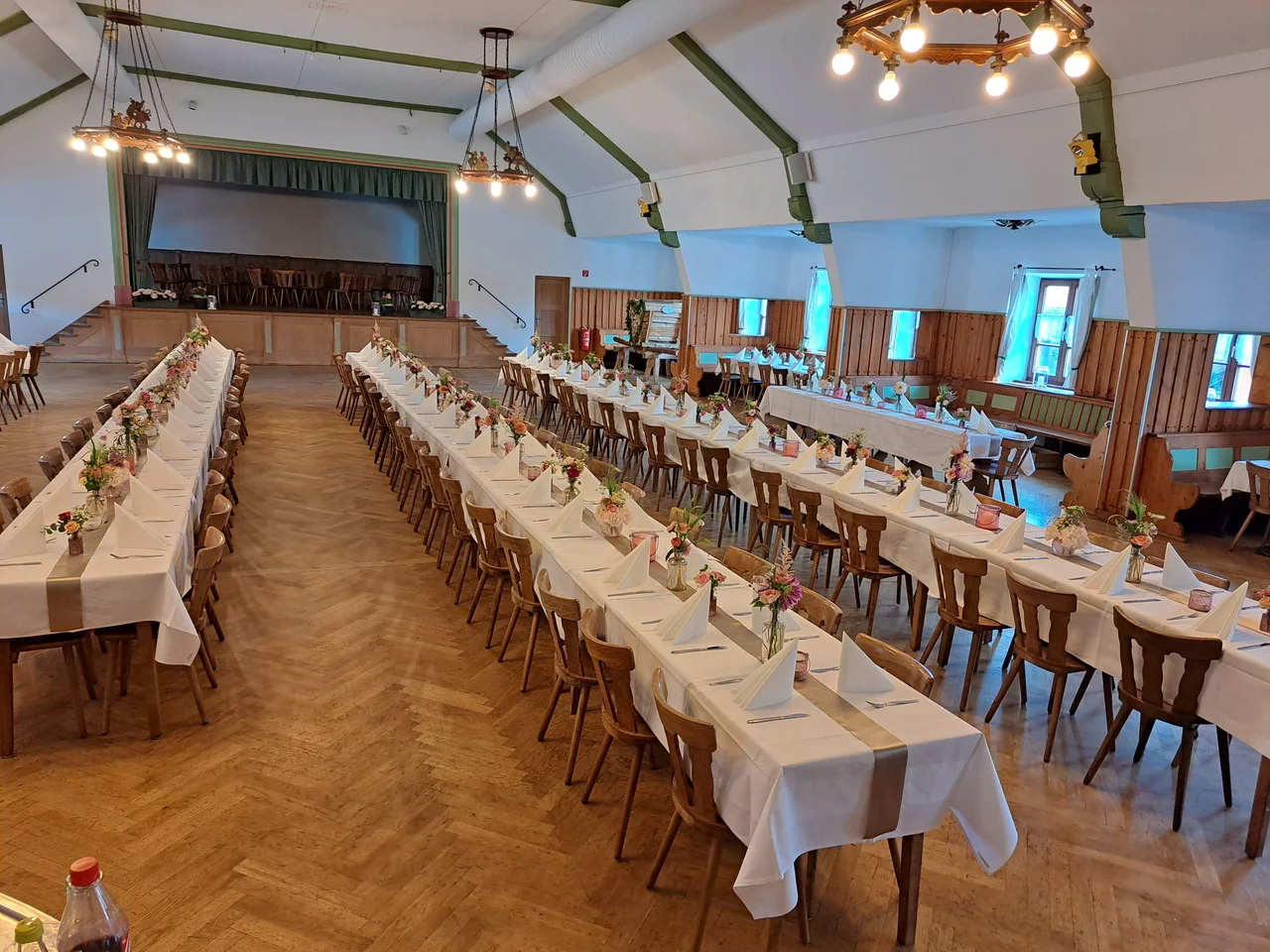 Großer Festsaal mit langen festlich gedeckten Tischen für Feiern in Bichl